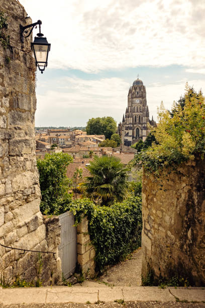 Vue aérienne de Saintes au coucher du soleil : la cathédrale Saint-Pierre, l'arc de Germanicus, la Charente et l'église Saint-Eutrope au loin.